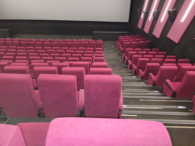 Empty Movie Theater with Red Seats and Blank Screen