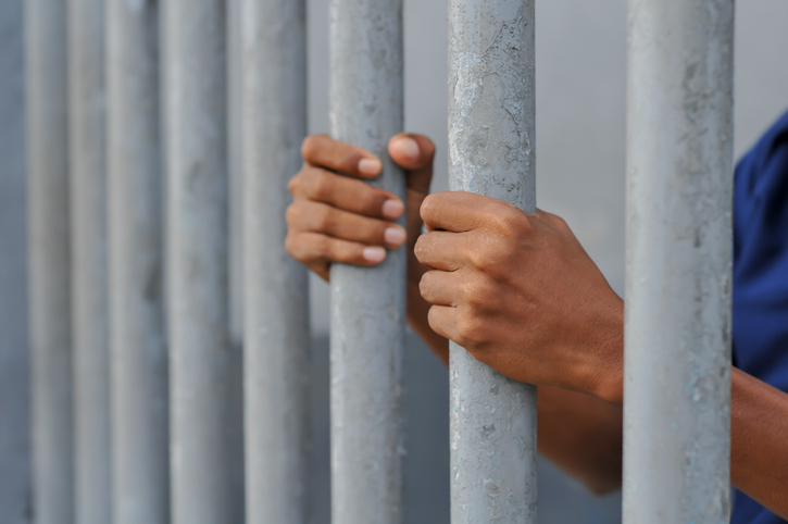 hands of prisoners behind bars