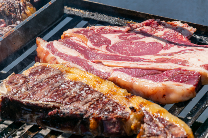 preparing gourmet beef steaks on an outdoor barbecue two stages of cooking beef raw and grilled on bbq