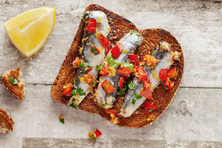Bruschetta and sardine, Sandwich with smoked sprats. Small sandwiches with sardine. Sandwiches with sardine on toasted slices of bread. Sandwich with Sardine and avocado sauce.