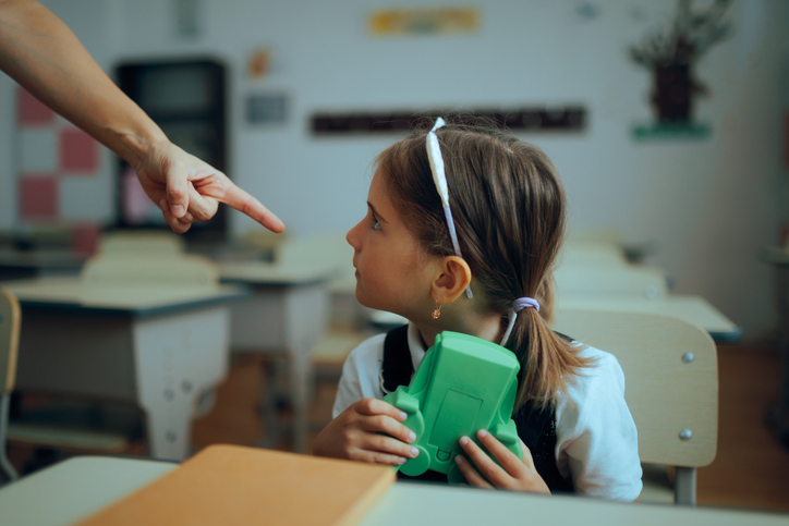 Teacher Scolding Student For Playing with a Game Toy