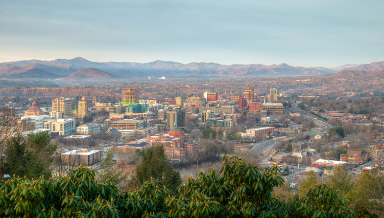 Low aerial shot of downtown Asheville, North Carolina and surrounding mountains