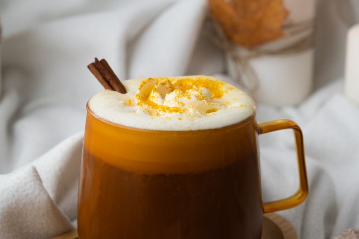Pumpkin spiced latte morning warming coffee. Fall Drinks for Halloween Thanksgiving Holiday beverage Autumn spicy cinnamon flavor seasonal hot drinking in cozy orange cup. Atmosphere of cold rainy days